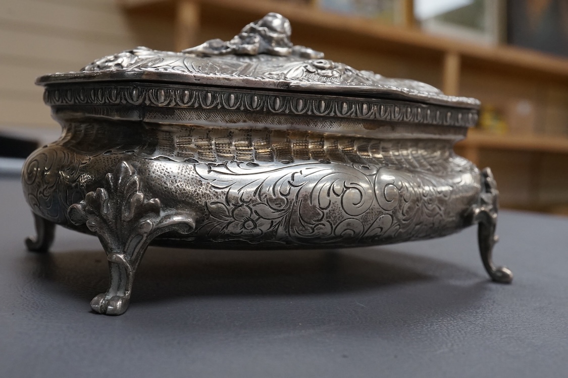 An ornate early 20th century Italian 800 standard white metal trinket casket, of shaped oval form, with embossed and engraved decoration, on four cabriole feet, 12.2cm, 9.2oz.